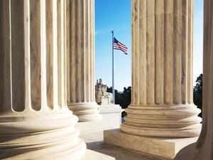 American Flag Seen Through Columns