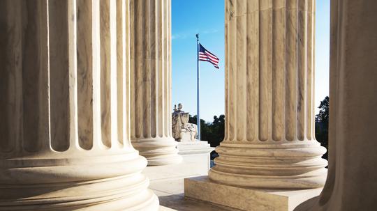 American Flag Seen Through Columns