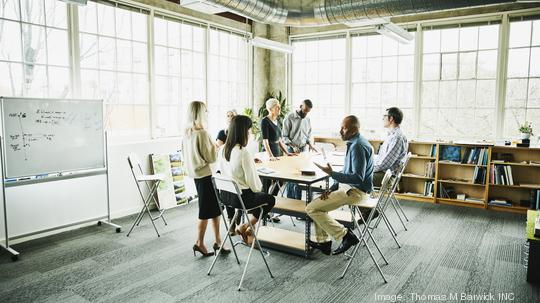 Architects and engineers in project planning meeting at conference table in design studio