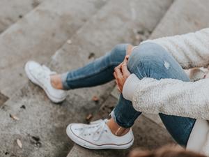 Female feet in jeans and sports shoes