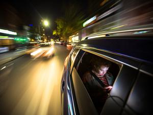 Woman in Rear of Car Driving Through New York City