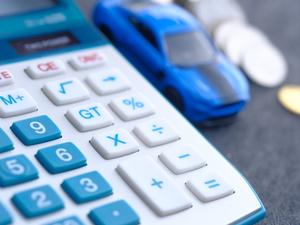 calculator, coins and car on desk