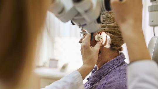 ENT physician examining ear of a senior woman