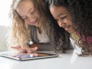 Fabulingua - Smiling girls using digital tablet