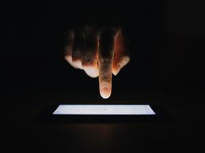 Close up of woman's hand checking emails on smartphone  against black background