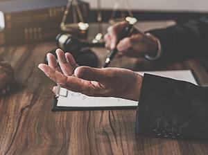 Midsection Of Judge And Client Sitting At Table In Office