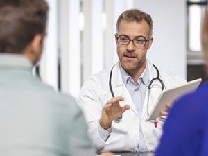 Doctor talking to couple in medical practice