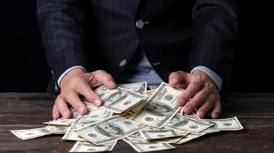 Midsection Of Man With Paper Currencies On Table