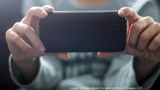 Close up of Caucasian boy photographing with cell phone