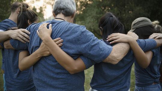 Volunteers hugging in huddle