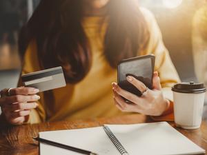 Midsection Of Woman Using Mobile Phone On Table At Cafe