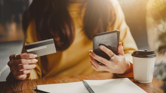 Midsection Of Woman Using Mobile Phone On Table At Cafe