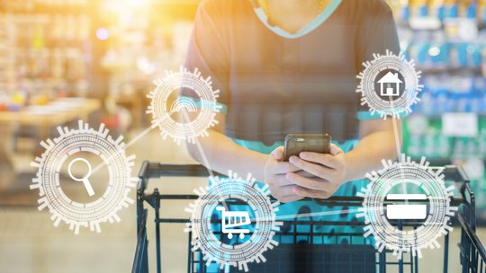 girl leaning on shopping cart, using a mobile phone, trolley in department store bokeh with online shopping and payment icon customer network connection on screen, m-banking for marketing technology