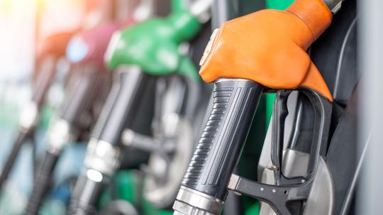 Pumping equipment gas at gas station. Close up of a hand holding fuel nozzle