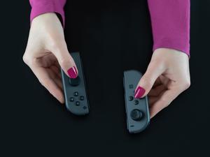 Top View Of Woman Hands With Pink Nail Polish On Fingers Holding Nintendo Switch Gaming