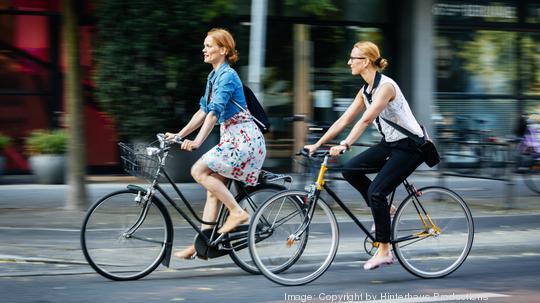 Two women cycling in the city