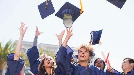 Graduates tossing caps into the air