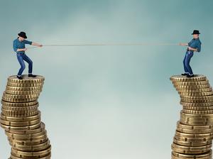 Two men on top of coins in tug of war, business competition concept