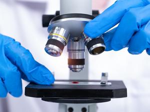 scientist looking through a microscope in a laboratory. Young scientist doing some research.