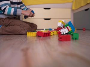 a little boy playing with colored cubes on the floor