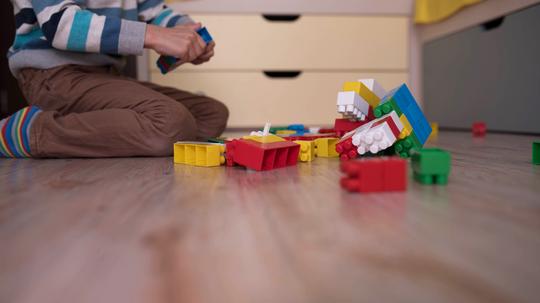 a little boy playing with colored cubes on the floor