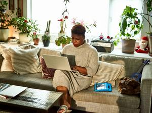 Woman working from home on sofa with laptop