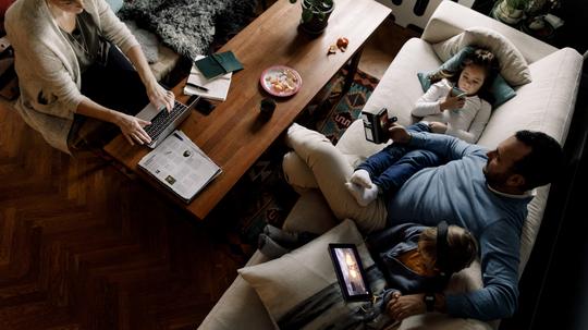 High angle view of family using various technologies in living room at home