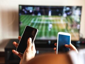 Friends using mobile phone during a tennis match