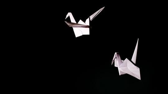 Paper Cranes Against Black Background