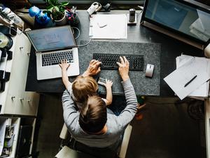 Aerial View Of Mother Working In Office At Home With Daughter