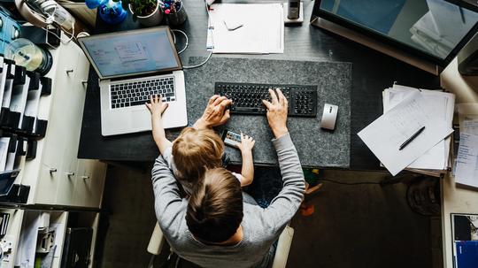 Aerial View Of Mother Working In Office At Home With Daughter