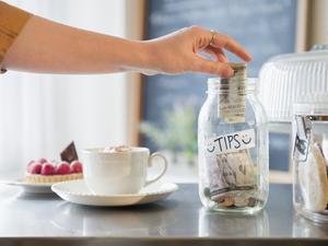 Caucasian woman putting money in tip jar