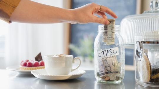 Caucasian woman putting money in tip jar