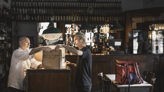 Delivery Person Receiving Order in a Restaurant