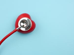 High Angle View Of Red Heart Model With Stethoscope Over Blue Background