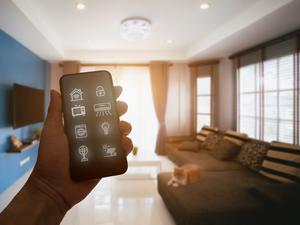 Mobile phone with smart home app in modern living room