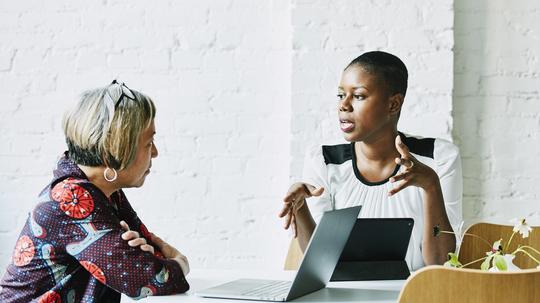 Female financial advisor in discussion with client in office conference room