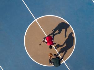 Aerial shot of 2 basketball players and shadows