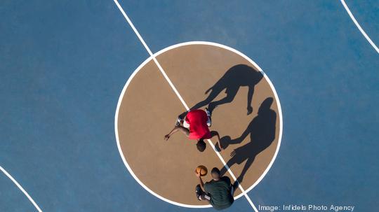 Aerial shot of 2 basketball players and shadows