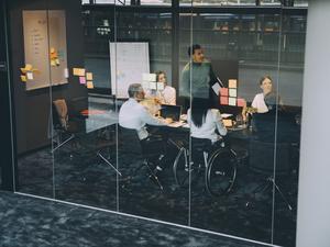 Confident businessman explaining strategy to colleagues in board room at office