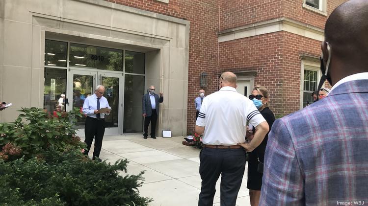 Paul Cooper, vice president of Alex Cooper Auctioneers, reads a seven-page legal document outlining the conditions of the pending auction Friday for the Mazza Gallerie outside the auctioneer's D.C. office.