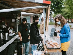 Masked Customer Orders Coffee And Snacks at Food Truck