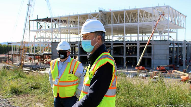 Cree CEO Gregg Lowe, center, visited Utica last week to check in with employees at the fab under construction, tour the site with Jeff Maidment, construction manager for Cree, and meet with local partners.