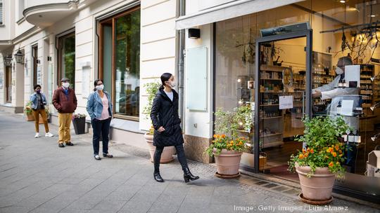 People waiting in the queue outside pharmacy with social distancing