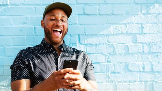 Man laughing with smart phone