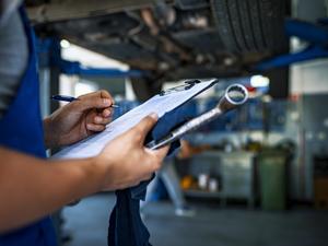 Automotive specialist adjusting an engine