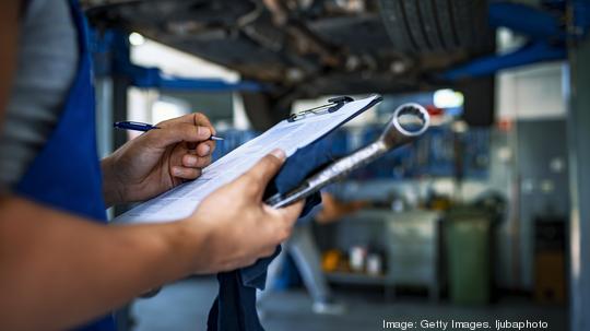 Automotive specialist adjusting an engine