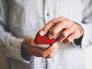 A man holding a red ring box