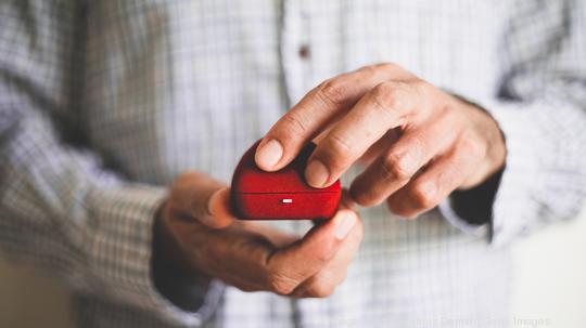 A man holding a red ring box