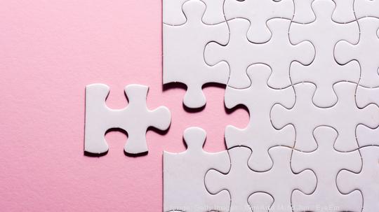 High Angle View Of Jigsaw Puzzle On Pink Background